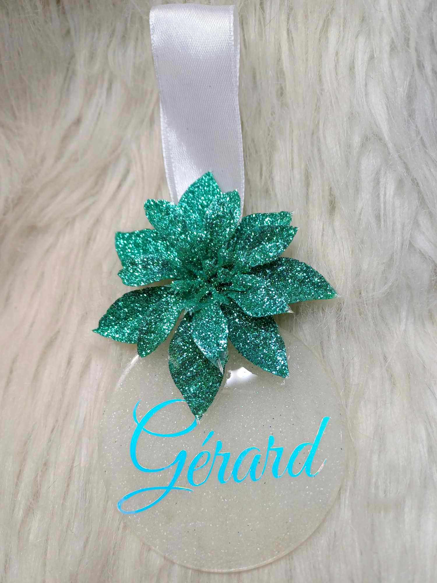 Boule de  Noël personnalisée Poinsettia, et au prénom de votre choix.  Une décoration toute en paillettes  blanche à offrir, ou à s'offrir.